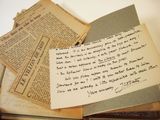 a pile of old papers and a piece of paper with writing on it