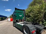 a green truck that is parked on the side of the road