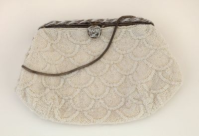 beige beaded purse on white background with brown leather strap