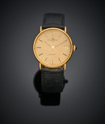 une montre-bracelet plaquée or avec bracelet en cuir noir