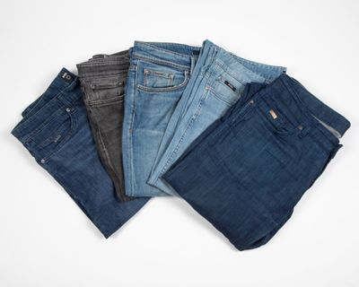 five pairs of jeans stacked on top of each other