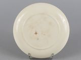 underside view of a white plate with a brown spot in the center