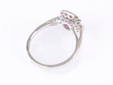 a close up of a ring with a pink sapphire and diamonds