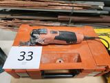 une perceuse filaire posée sur une boîte sur laquelle est apposée une étiquette de prix