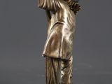 bronze statue of a man holding a book in his right hand