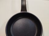 a black frying pan hanging on the wall