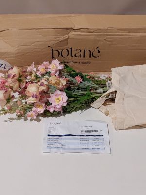 un bouquet de fleurs posé sur une table à côté d'un paquet