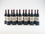 six bottles of red wine lined up in a row on a white surface