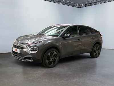 Le SUV gris est garé dans une grande pièce aux murs blancs.
