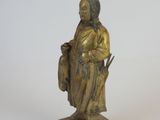 bronze statue of a woman holding a bag and a bird on a stand
