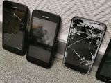 four cell phones are sitting next to each other on the floor