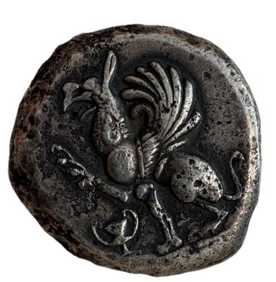 une vieille pièce d'argent sur laquelle figurent un oiseau et un crâne