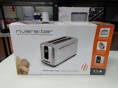 packaging of a silver toaster sitting on top of a white table