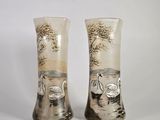 deux vases ornés de cygnes, posés sur une table
