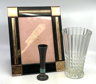 une photo représentant un cadre et un vase posés sur une table