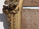 a mirror with a gold frame on a white wall