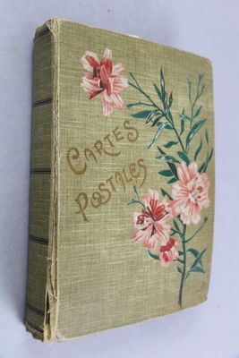 an old book with flowers on it on a table
