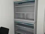 a desk with a chair and a bookcase in the corner