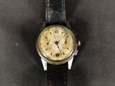 an old watch that is sitting on a black surface