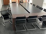 une longue table entourée de chaises dans une salle de réunion