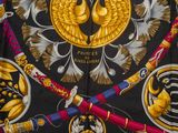 a black and gold scarf with a picture of a bird on it