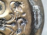 a close up of a metal plate with a design on it