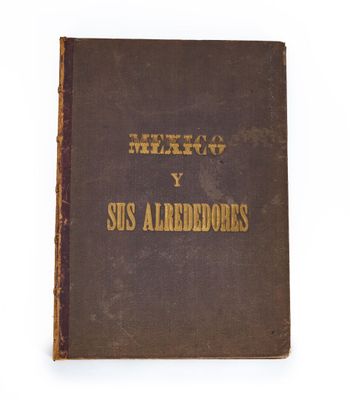 un vieux livre orné de lettres dorées, posé sur une surface blanche