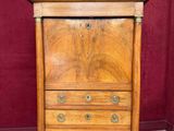 une armoire en bois avec un plateau en marbre et un miroir accroché au mur