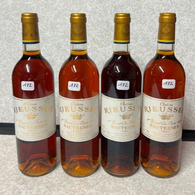 quatre bouteilles de vin sont alignées sur un comptoir