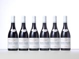 six bottles of wine are lined up on a table