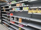 many empty shelves in a grocery store filled with food