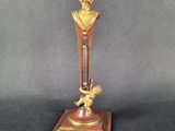 brass and red clock with a statue of a man holding a child