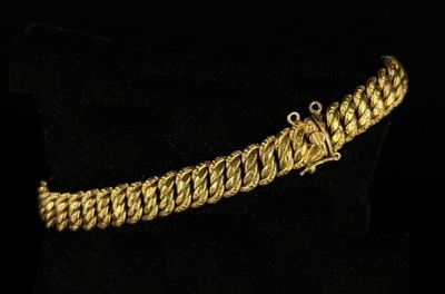 a close up of a gold bracelet on a black surface