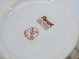 a close up of a white bowl with a red logo on it