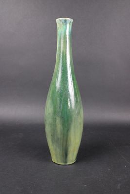 a green vase that is sitting on a black surface