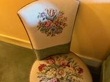 a green chair with a floral design on it next to a green chair