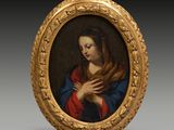 un tableau ovale représentant une femme tenant ses mains dans sa main droite