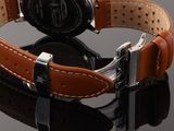 a close up of a watch on a black surface