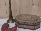 une table sur laquelle se trouvent un vase, une bougie et d'autres objets