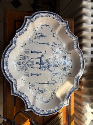 a blue and white plate sitting on top of a wooden cabinet