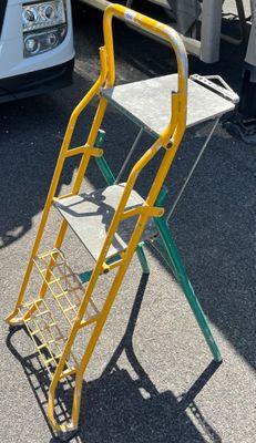 a yellow and green hand truck that is parked in the parking lot