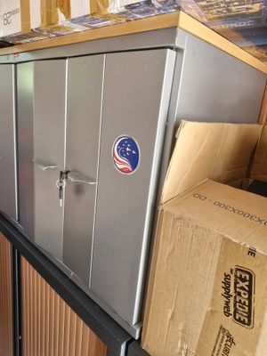 boxes are stacked on top of a metal cabinet in a room
