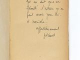 un livre ouvert, sur lequel est posée une note manuscrite, posé sur une table