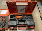 une boîte à outils orange contenant des outils, posée sur une table