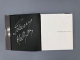 un livre ouvert, avec une couverture noire sur laquelle figurent des inscriptions blanches