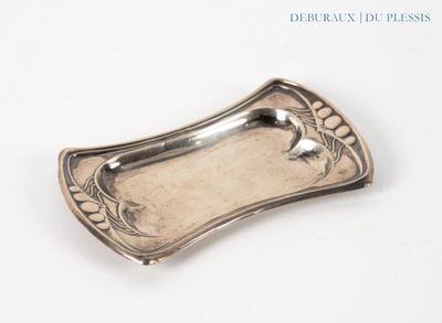 une assiette en argent ornée d'un oiseau sur un fond blanc