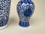 two blue and white vases sitting next to each other