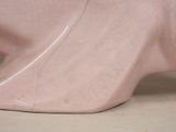 a pink elephant statue sitting on a white surface