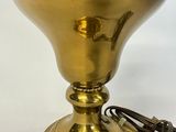 brass plated table lamp with cord plugged to the base