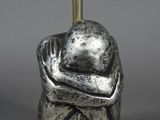 une image représentant une sculpture d'une personne tenant une lampe